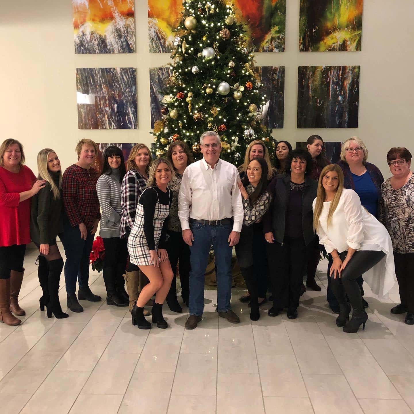 Smiling group poses by a Christmas tree indoors at Carpinello Orthodontics in Drexel Hill, Newtown Square or Edgmont, PA.
