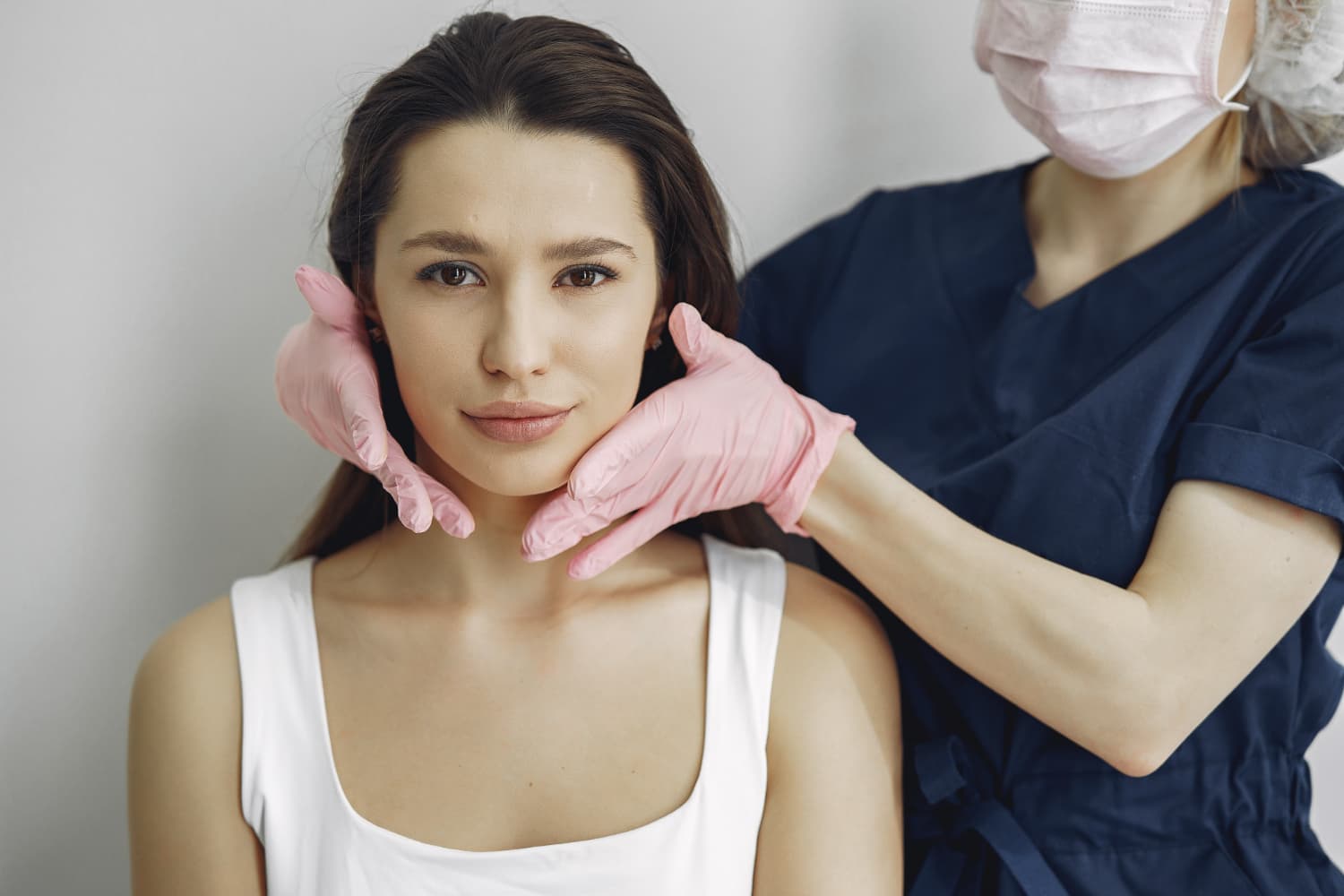 A Carpinello Orthodontics expert in Drexel Hill, Newtown Square or Edgmont, PA examines a woman's jaw for possible surgery.